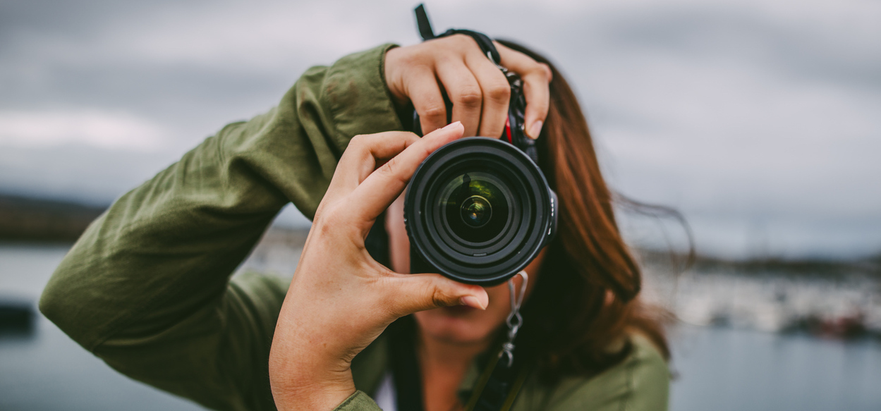 Young woman using DSLR camera